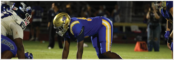 A group of football players on a field. Description generated by AI
