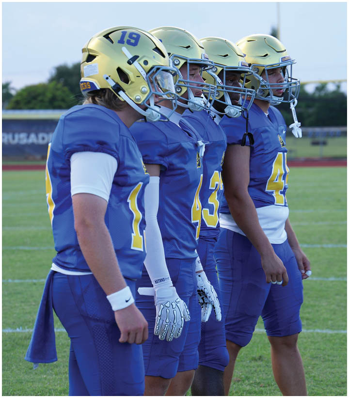 A group of football players wearing black and white uniforms. Description generated by AI