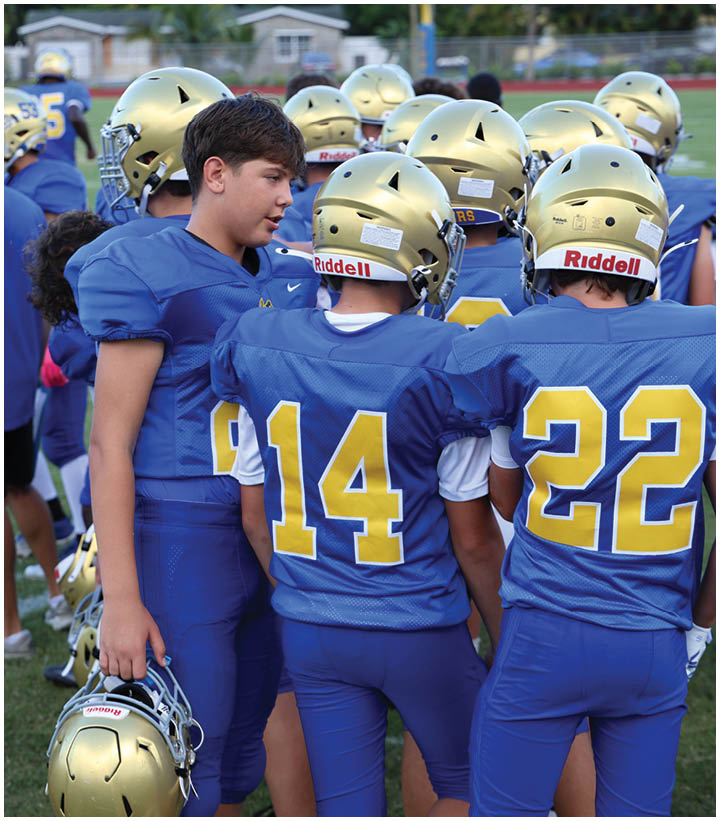 A group of football players wearing black and white uniforms. Description generated by AI