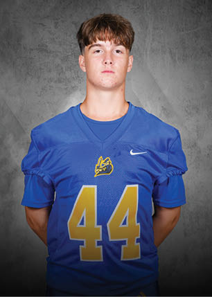 A young man wearing a white and black jersey with the number 14 on it. Description generated by AI