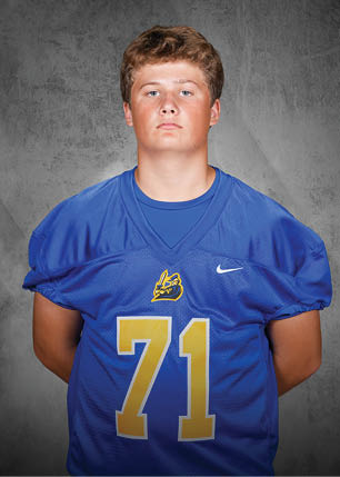 A young man wearing a white and black jersey with the number 14 on it. Description generated by AI