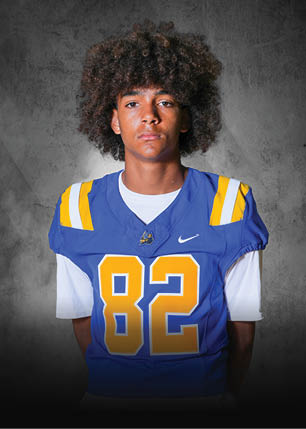 A young man wearing a white and black jersey with the number 14 on it. Description generated by AI