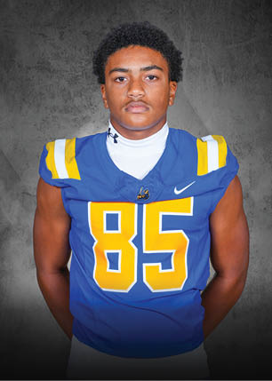 A young man wearing a white and black jersey with the number 14 on it. Description generated by AI