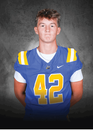 A young man wearing a white and black jersey with the number 14 on it. Description generated by AI