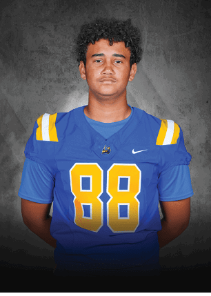 A young man wearing a white and black jersey with the number 14 on it. Description generated by AI