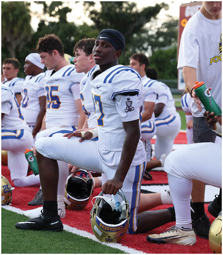 A group of football players wearing black and white uniforms. Description generated by AI