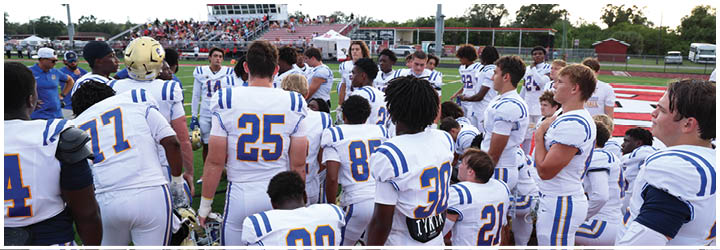 A group of football players on a field. Description generated by AI