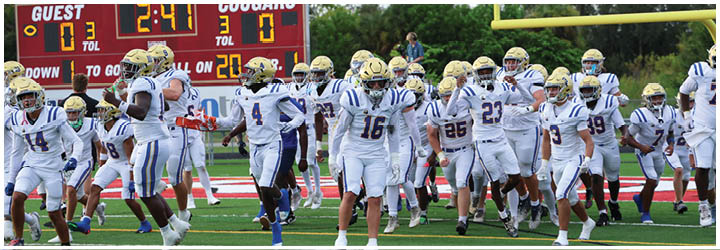 A group of football players on a field. Description generated by AI