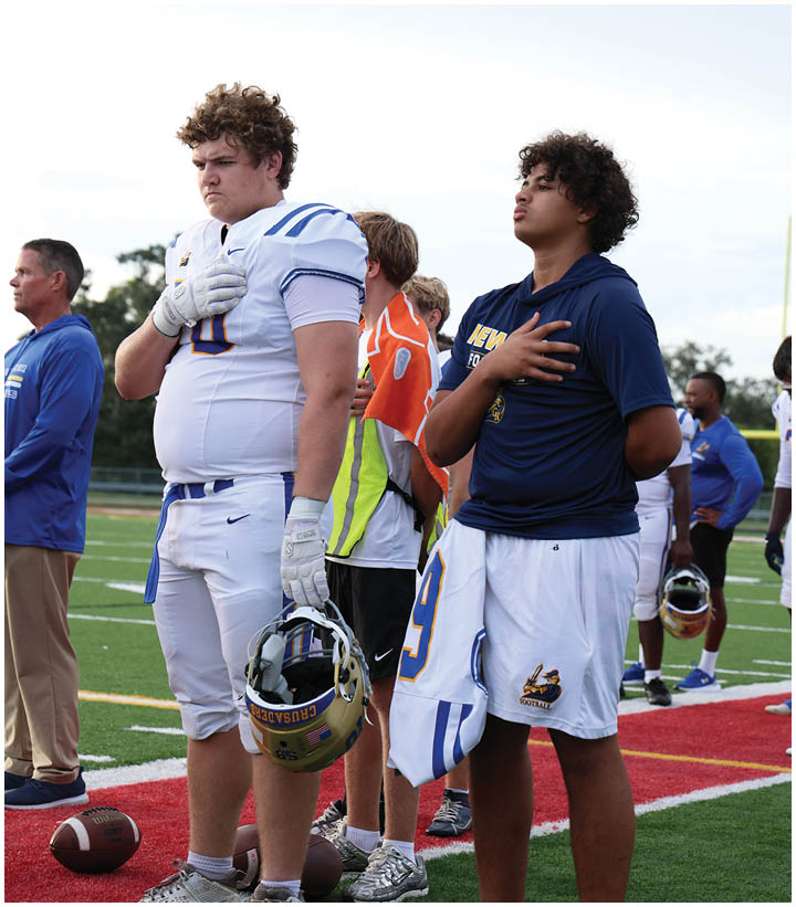A group of football players wearing black and white uniforms. Description generated by AI