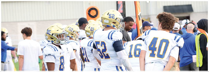 A group of football players on a field. Description generated by AI