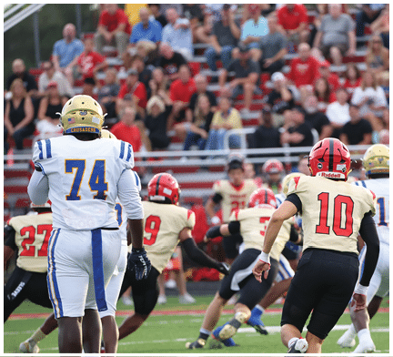 A group of football players huddled together on the field. Description generated by AI