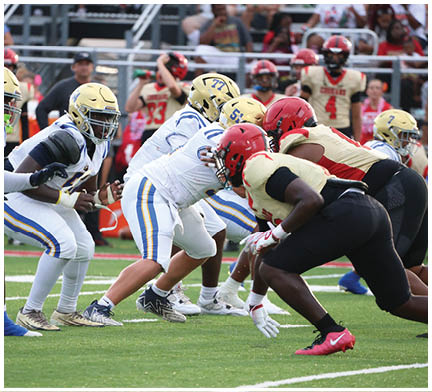 A group of football players huddled together on the field. Description generated by AI