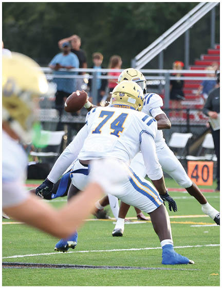 A football player wearing a blue and white uniform. Description generated by AI