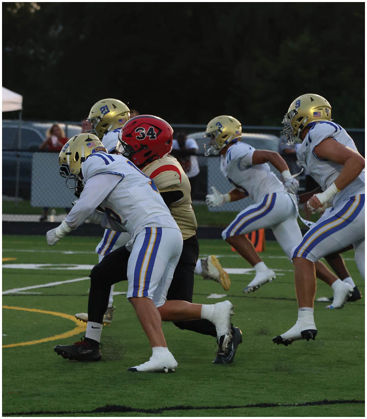 A group of football players wearing black and white uniforms. Description generated by AI