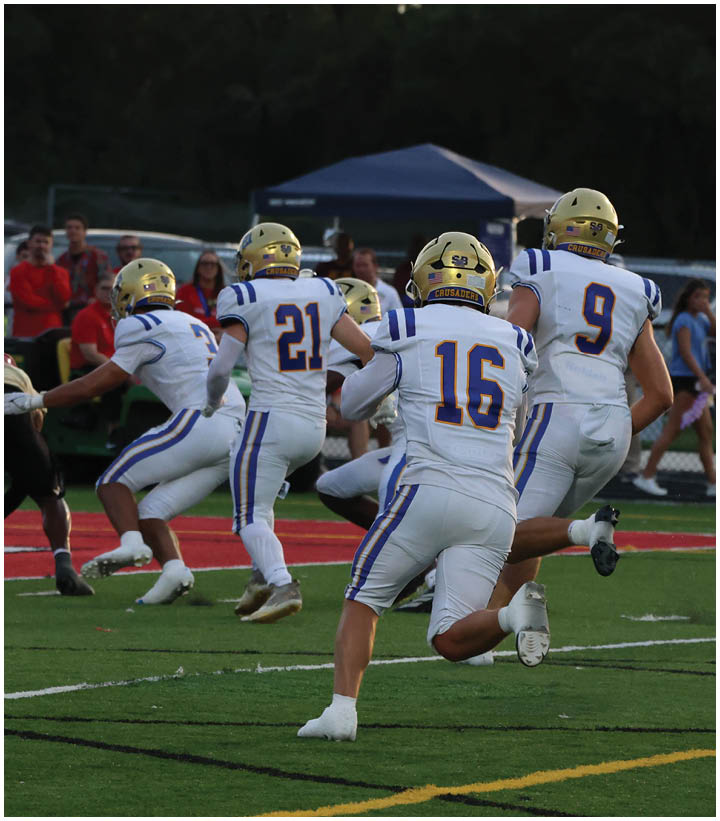 A group of football players wearing black and white uniforms. Description generated by AI