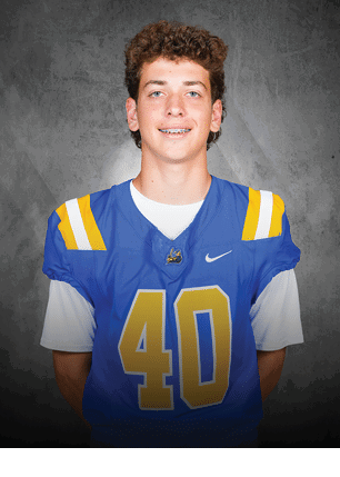 A young man wearing a white and black jersey with the number 14 on it. Description generated by AI
