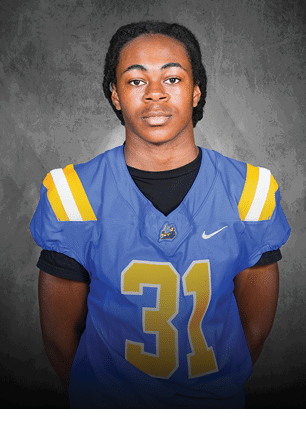 A young man wearing a white and black jersey with the number 14 on it. Description generated by AI