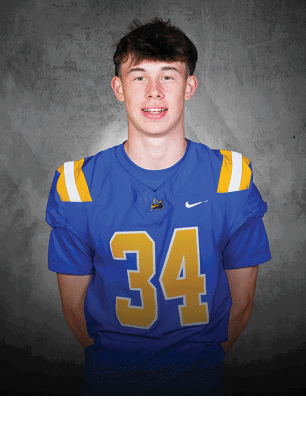 A young man wearing a white and black jersey with the number 14 on it. Description generated by AI