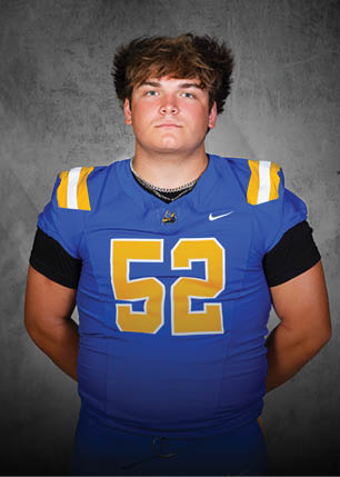 A young man wearing a white and black jersey with the number 14 on it. Description generated by AI
