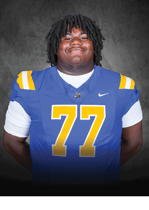 A young man wearing a white and black jersey with the number 14 on it. Description generated by AI
