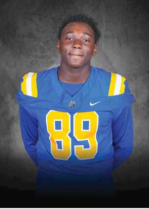 A young man wearing a white and black jersey with the number 14 on it. Description generated by AI