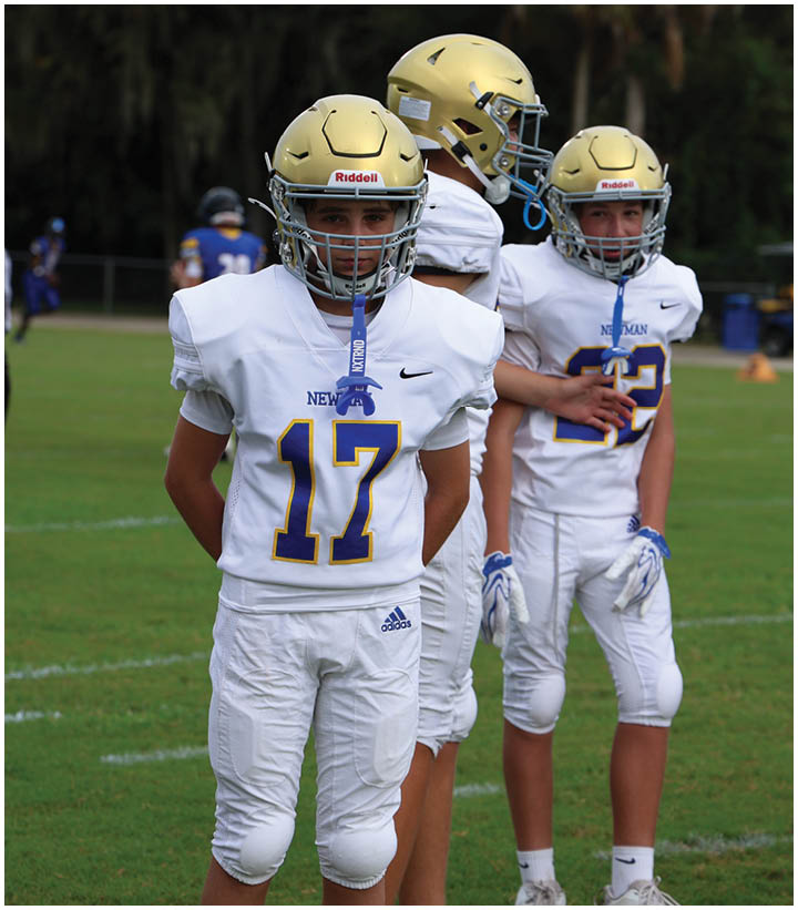 A group of football players wearing black and white uniforms. Description generated by AI