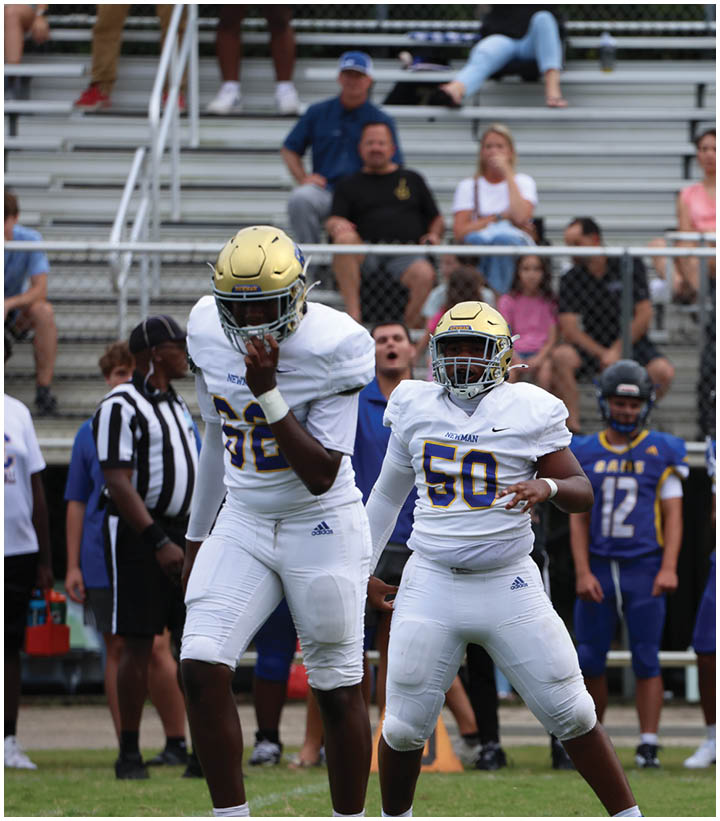 A group of football players wearing black and white uniforms. Description generated by AI