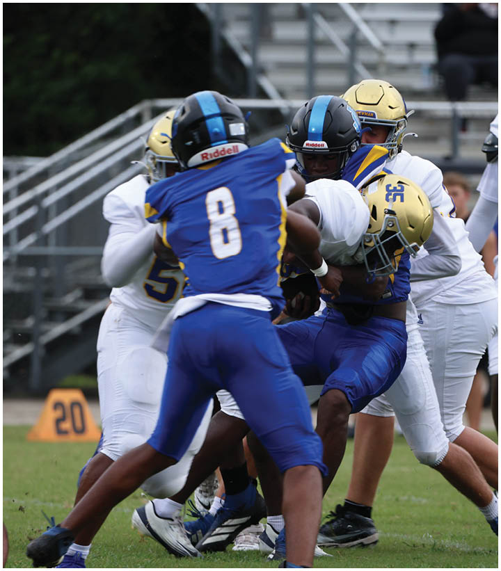 A group of football players wearing black and white uniforms. Description generated by AI