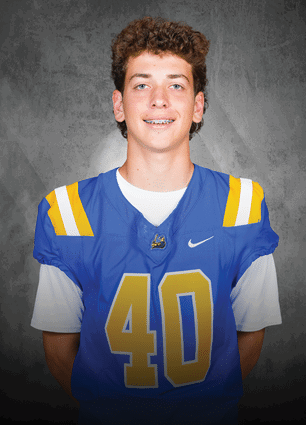 A young man wearing a white and black jersey with the number 14 on it. Description generated by AI