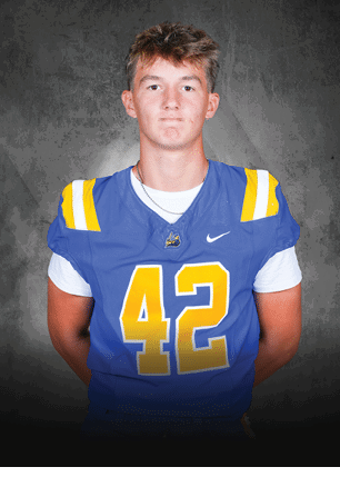 A young man wearing a white and black jersey with the number 14 on it. Description generated by AI