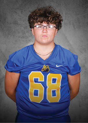 A young man wearing a white and black jersey with the number 14 on it. Description generated by AI