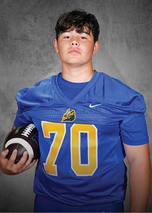 A young man wearing a white and black jersey with the number 14 on it. Description generated by AI