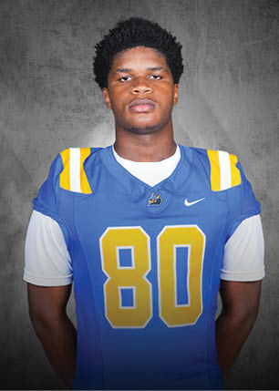 A young man wearing a white and black jersey with the number 14 on it. Description generated by AI