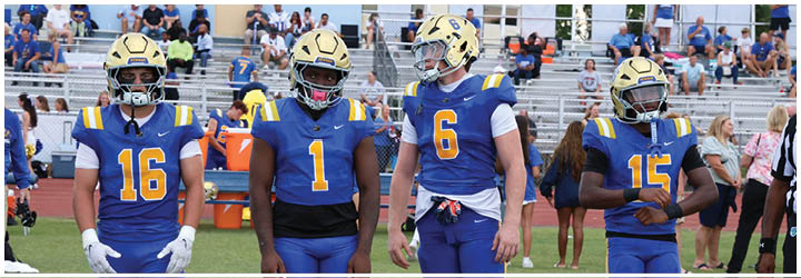 A group of football players on a field. Description generated by AI