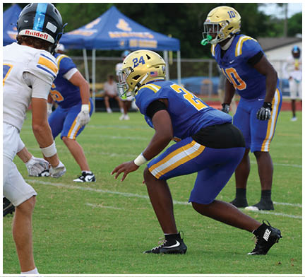 A group of football players huddled together on the field. Description generated by AI