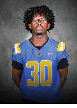 A young man wearing a white and black jersey with the number 14 on it. Description generated by AI