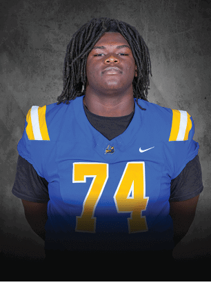 A young man wearing a white and black jersey with the number 14 on it. Description generated by AI