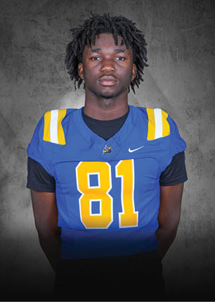 A young man wearing a white and black jersey with the number 14 on it. Description generated by AI