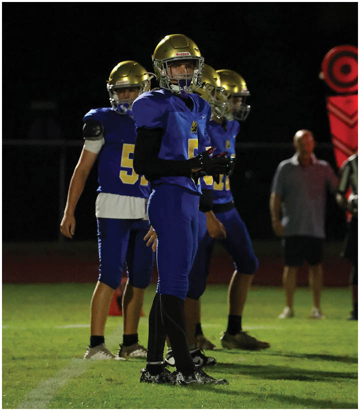 A group of football players wearing black and white uniforms. Description generated by AI