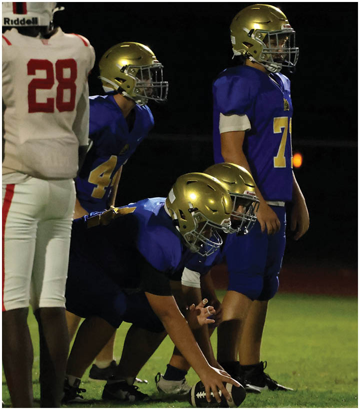 A group of football players wearing black and white uniforms. Description generated by AI