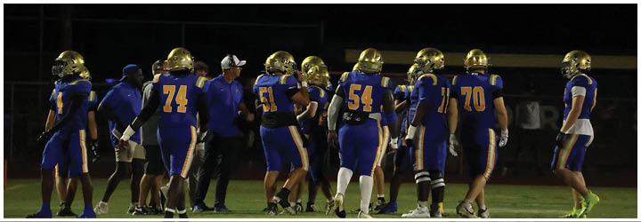 A group of football players on a field. Description generated by AI