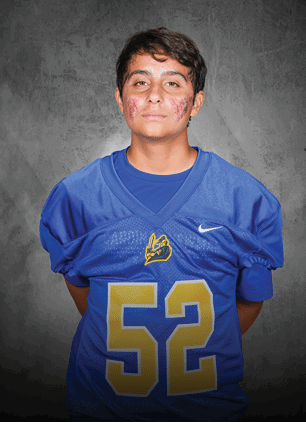 A young man wearing a white and black jersey with the number 14 on it. Description generated by AI