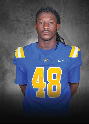 A young man wearing a white and black jersey with the number 14 on it. Description generated by AI