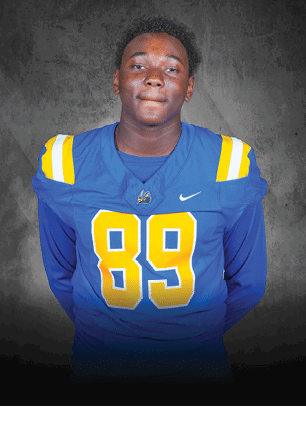 A young man wearing a white and black jersey with the number 14 on it. Description generated by AI