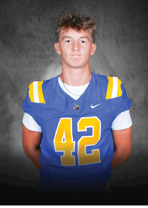 A young man wearing a white and black jersey with the number 14 on it. Description generated by AI
