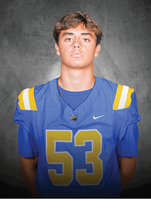 A young man wearing a white and black jersey with the number 14 on it. Description generated by AI