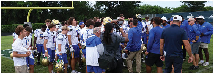 A group of football players on a field. Description generated by AI