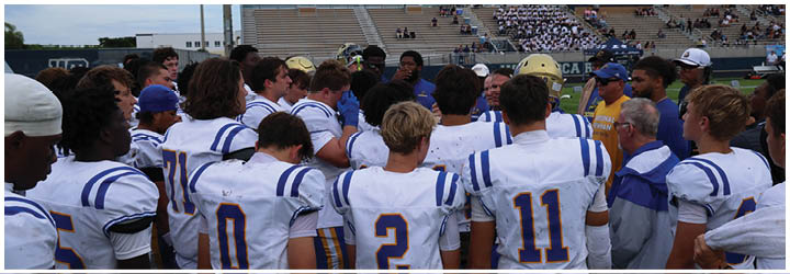 A group of football players on a field. Description generated by AI