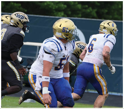 A football player wearing a blue and white uniform. Description generated by AI