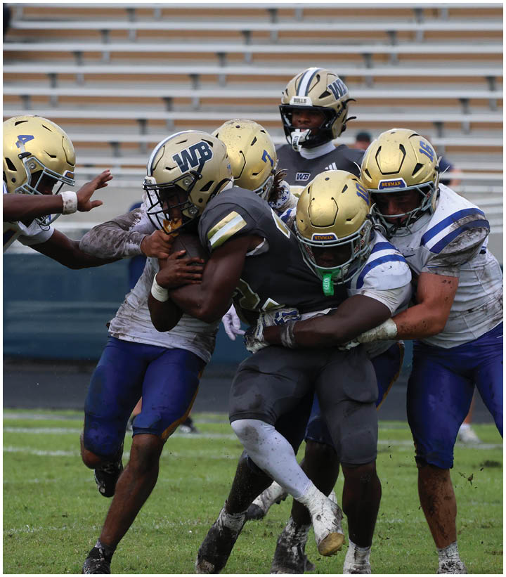 A group of football players wearing black and white uniforms. Description generated by AI